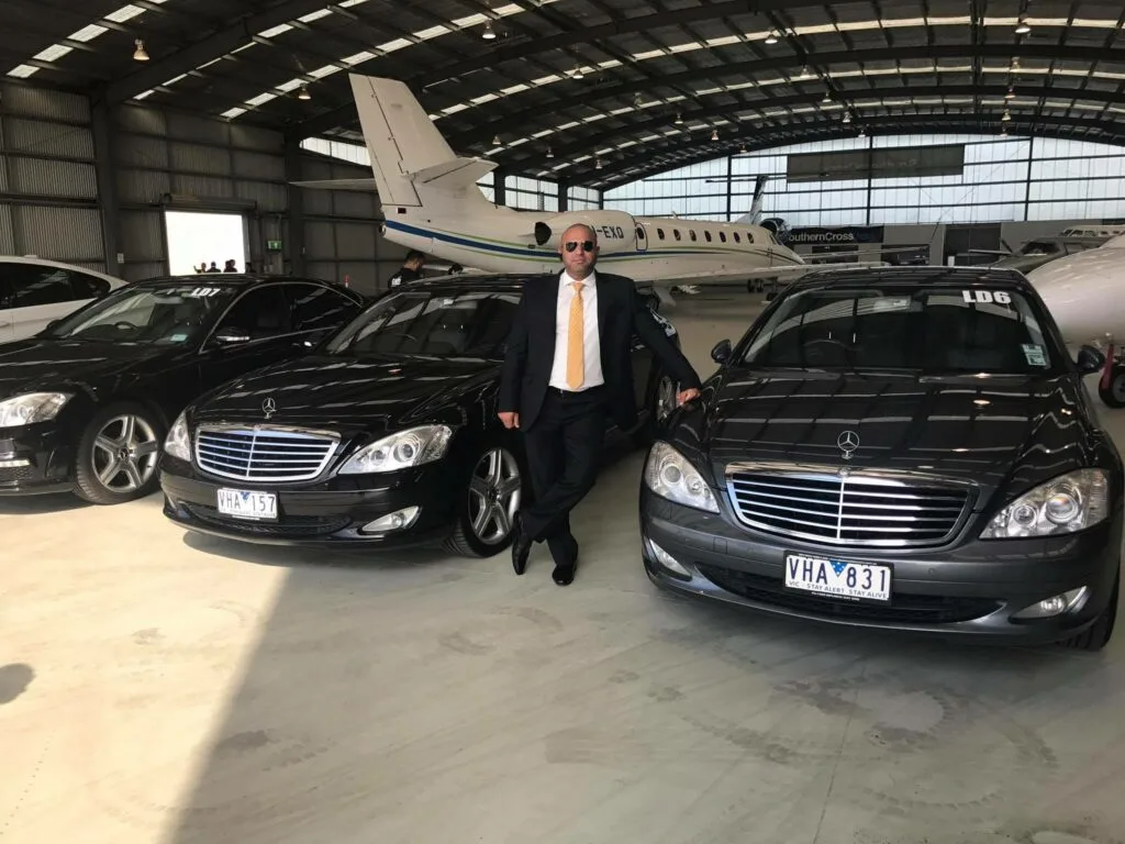 Vikram, founder of Diplomat Chauffeur Cars, beside a luxury Mercedes-Benz in Melbourne