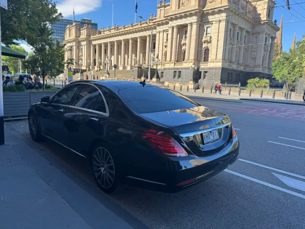 Luxury chauffeur car in Melbourne CBD during summer events, premium black Mercedes for Australian Open and concerts transportation.