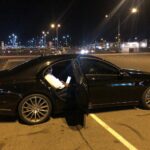 Luxury chauffeur opening Mercedes sedan door for passenger in Melbourne night chauffeur service