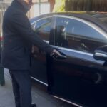 Professional chauffeur opening luxury sedan door for passenger in Melbourne private chauffeur service