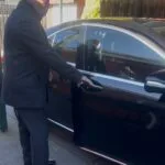Professional chauffeur opening luxury sedan door for passenger in Melbourne private chauffeur service