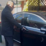 Professional chauffeur opening luxury sedan door for passenger in Melbourne private chauffeur service